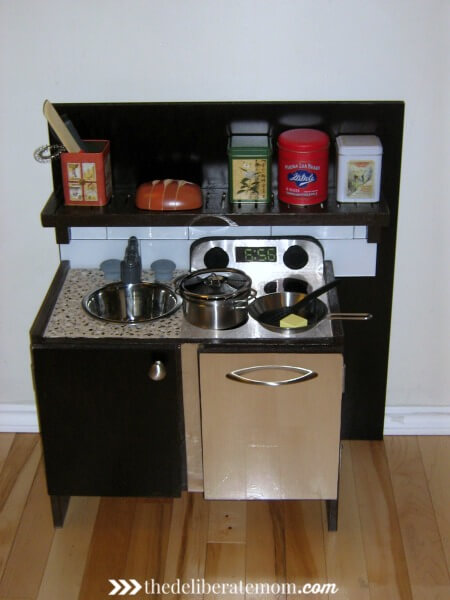 A play kitchen DIY project! We worked to make this kitchen look like our own kitchen. It was inexpensive and was built from the base of a small IKEA end table. Easy, cute, inexpensive and original! Check out these instructions on how to build a build a play kitchen! 