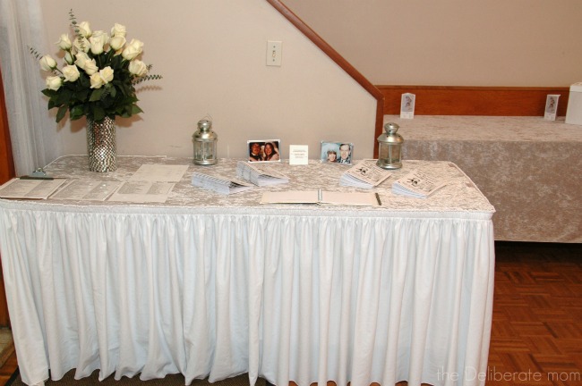 The table at the entrance of the hall has wedding photos of the bride and groom's parents.