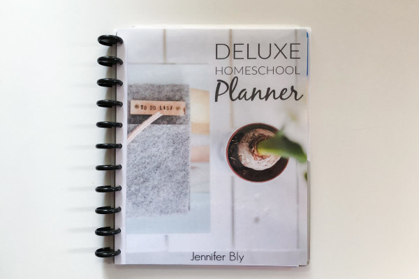 Disc bound homeschool planner on a white table