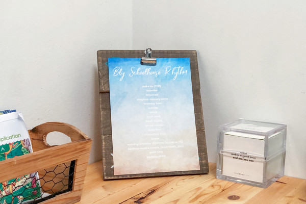 Schoolhouse rhythm schedule displayed on a clipboard in the kitchen.